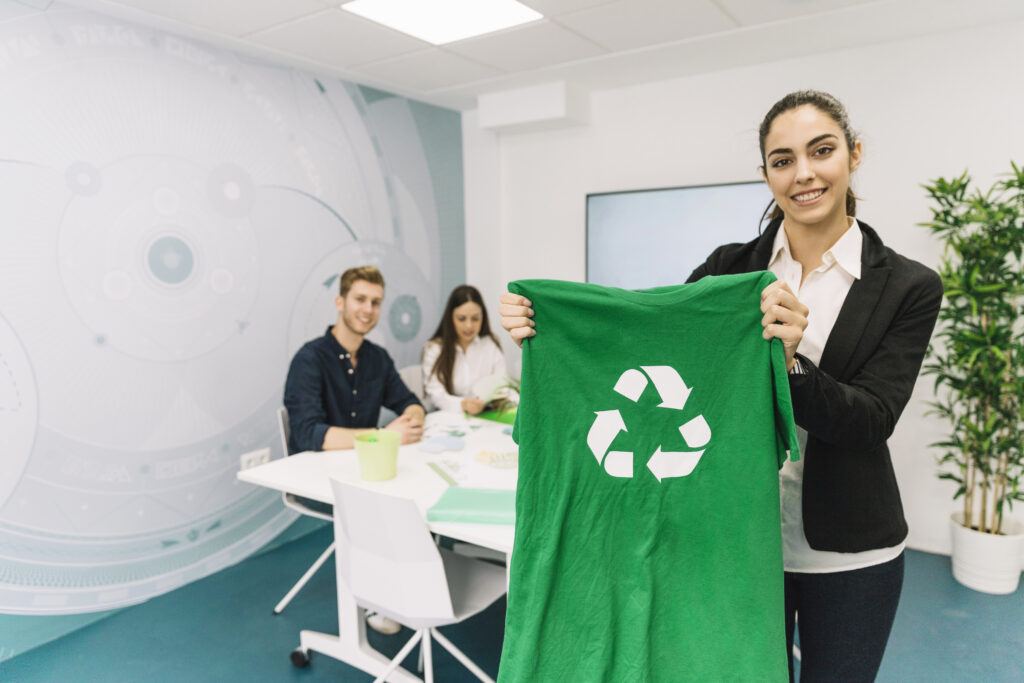 portrait-happy-young-businesswoman-showing-green-t-shirt-with-recycle-icon